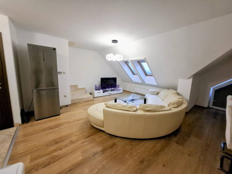 Living room in a 3-room apartment with a beige sofa and a wooden decor floor.