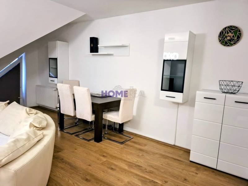 A bright living room in a three-room apartment with wooden decor flooring and light furniture.