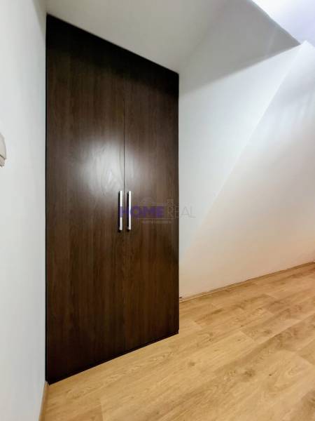 A wardrobe with double doors, a floor with wooden decor in a three-room apartment.