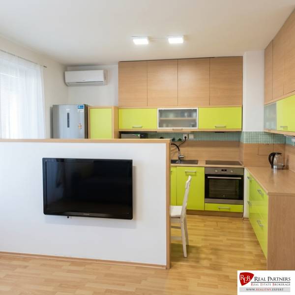 A kitchen in a 2-room apartment with wooden decor and light green furniture.