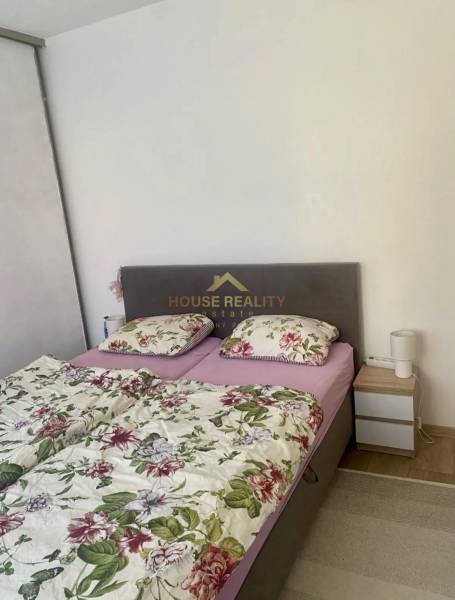 Bedroom in a 3-room apartment with a bed and floral bedding on the bed.