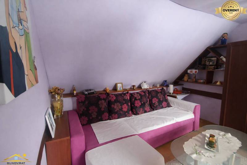 Purple room in a family house with a pink sofa and decorative pillows.