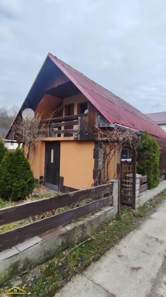 A family house in Horelica in Čadca with a red roof and a wooden fence.
