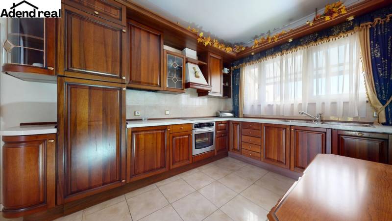 A kitchen with wooden decor, white curtains, and ceramic tiles in a 5 or more room apartment.