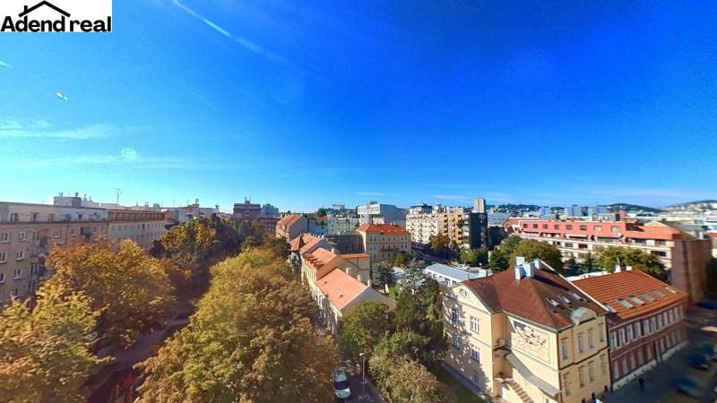 A view of Bratislava from Lazaretská Street, surrounded by greenery and rooftops of buildings.