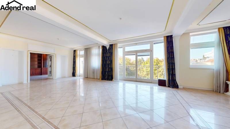 A spacious living room with large windows in a 5 or more room apartment.