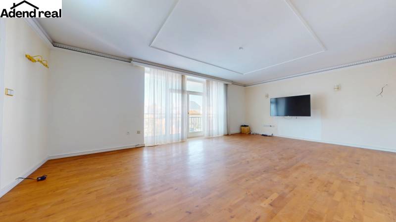 A spacious room in a 5 or more bedroom apartment with a wooden decor floor.