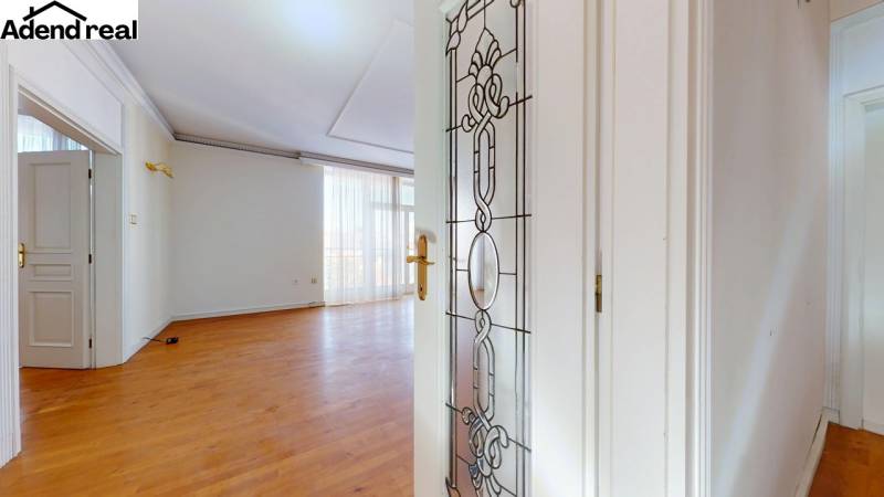 Interior of a 5 or more room apartment with white doors and a floor with a wood decor.