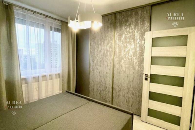 Bedroom with a large bed, built-in wardrobe, and curtains in a 2-room apartment.