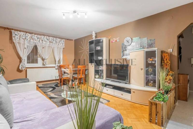 Living room in a 3-room apartment with a wooden decor floor and a comfortable sofa.