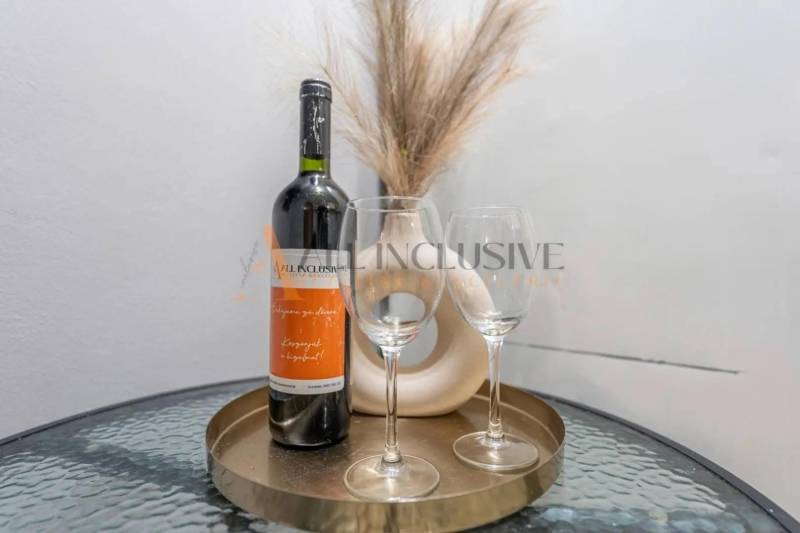 A bottle of wine and glasses on a round table in a 3-room apartment.