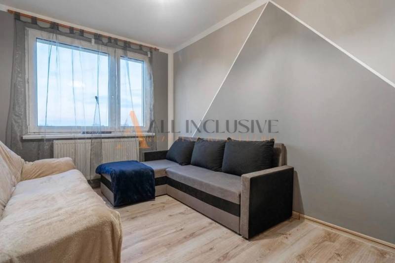 Living room with sofas and wooden decor flooring in a three-room apartment.