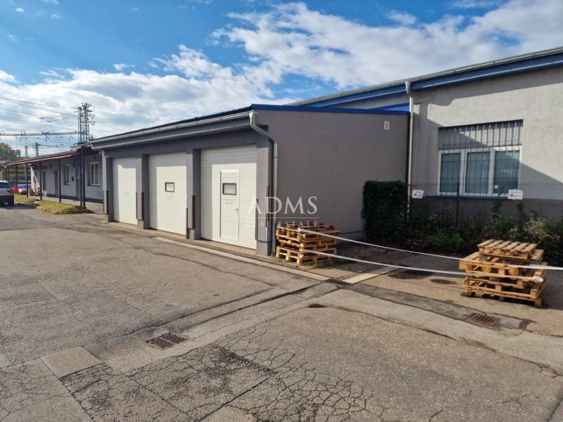 A building with garage doors, storage spaces near the railway track in Žilina.