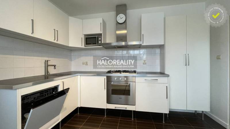 A kitchen in a 3-room apartment with white cabinets and stainless steel appliances.