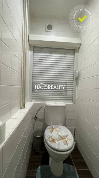 A bathroom in a 3-room apartment with tiles, a toilet, and decorative tiles.