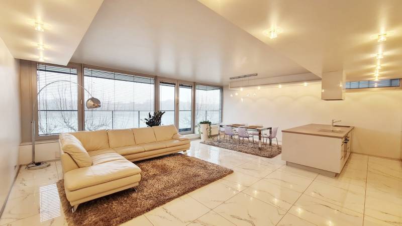 Spacious living area with a cream sofa in a 3-room apartment and glossy floor.