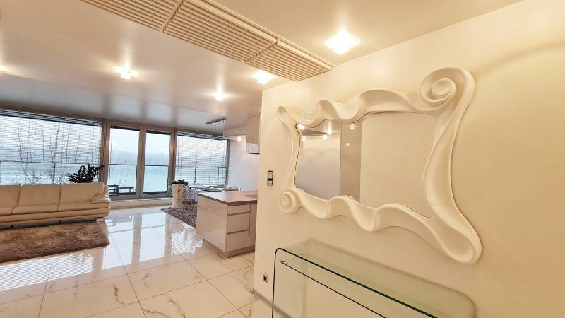 A modern interior of a 3-room apartment with large windows and a mirror.