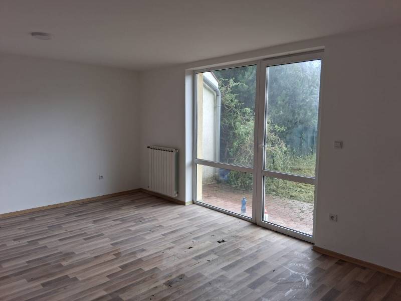 A room with a wooden decor floor in a family house and a view of the garden.