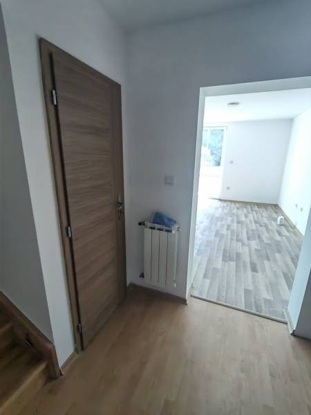 Interior of a family house with doors, a radiator, and a wooden decor floor.