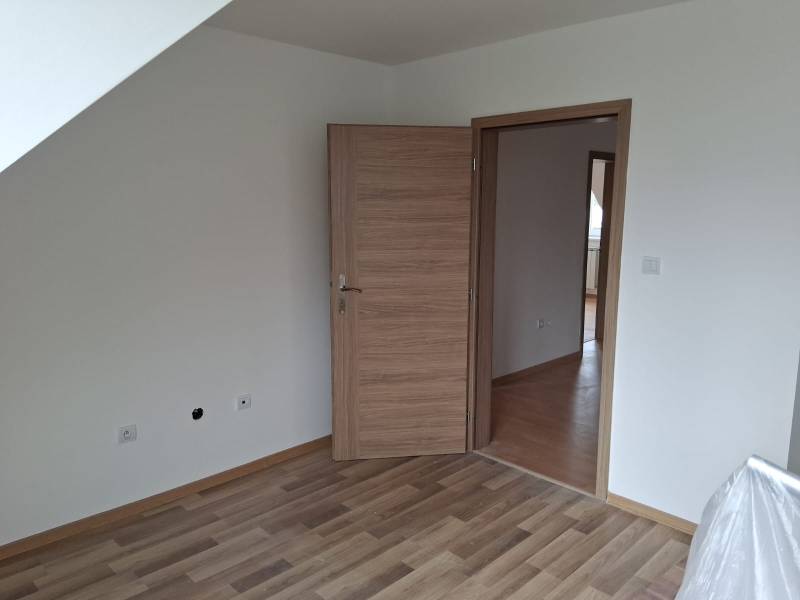 A room in a family house with a wooden decor floor and wooden doors.