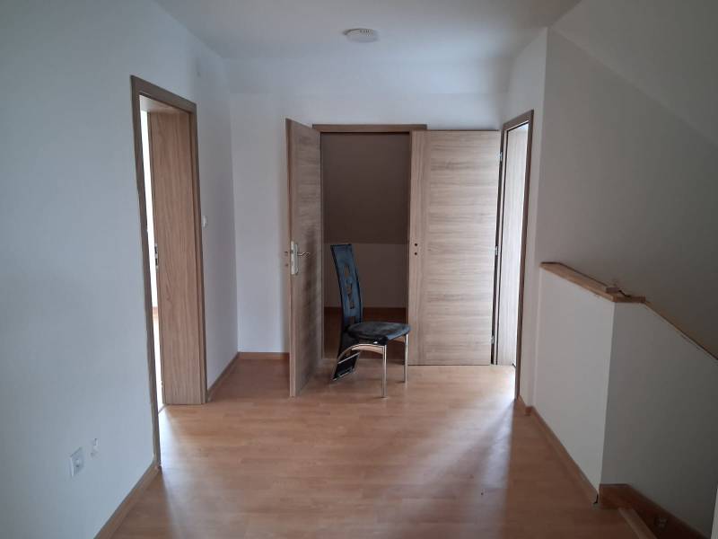 A room in a family house with a wooden decor floor and three wooden doors.