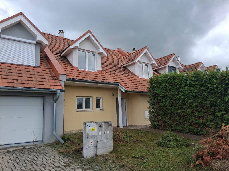 A family house in Ľubela with a red roof, a garage, and a well-maintained garden.