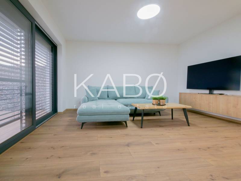 A living room in a family house with a wooden decor floor, light furniture, and a television.