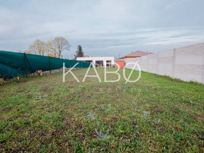 A garden next to a family house in Mojmírovce on the Fourth Row with panel fencing.