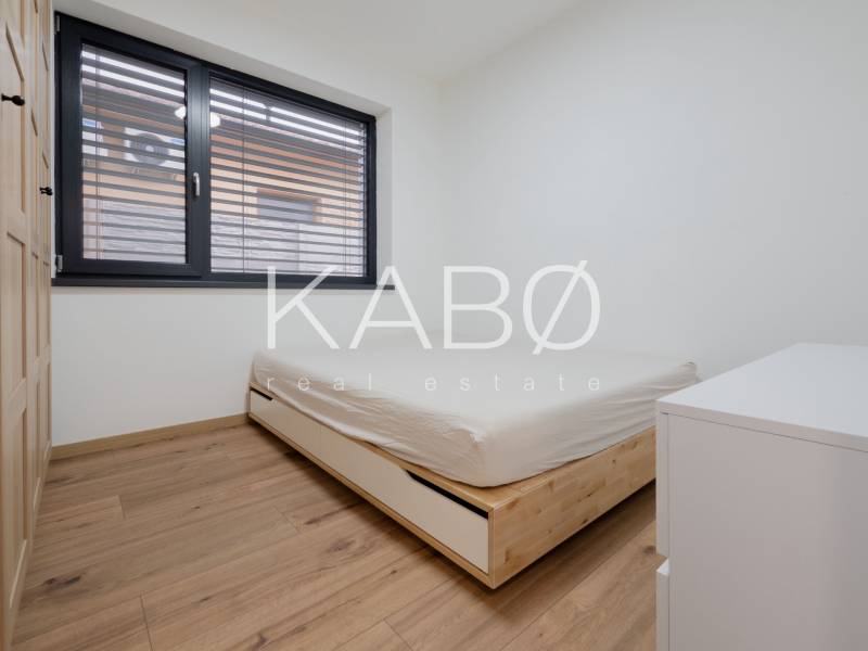 A bedroom with a bed and a wooden decor floor in a family house.