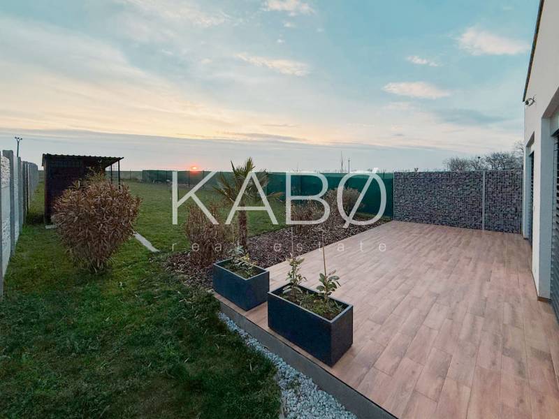 A family house on the Fourth Row in Mojmírovce with a terrace and a view of the garden at sunset.