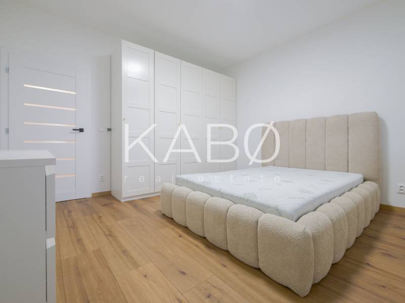 Bedroom in a family house with a bed and a wardrobe, floor with wooden decor.