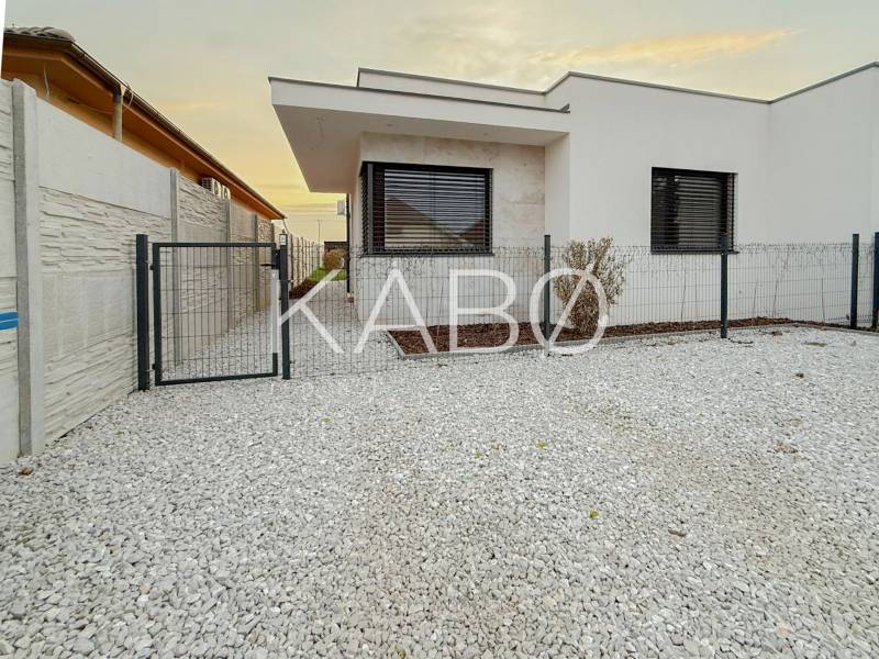 A family house on the Fourth Row in Mojmírovce with a stone front garden and a modern fence.