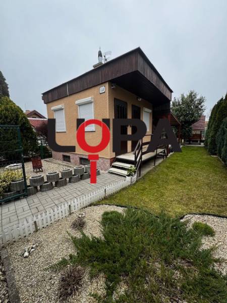 Cottage in Nové Zámky with a garden, lawn, and flowers, ideal for relaxation.