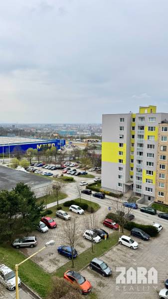 Apartment building on Sofijska Street in the Ťahanovce Housing Estate district, Košice, with a parking lot and a view.