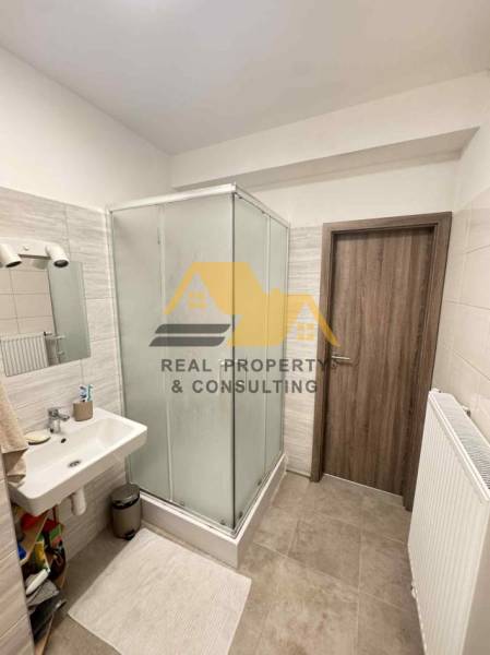 A bathroom in a 2-room apartment with a modern shower and tiles.