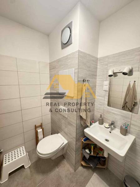 Bathroom in a 2-room apartment with ceramic tiles and sanitary ware.