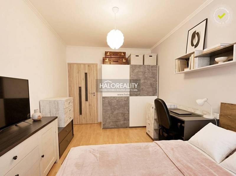 Bedroom in a 2-room apartment with wood-patterned flooring and storage space.