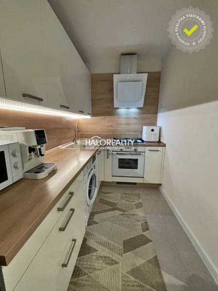A kitchen in a 2-room apartment with a wooden decor floor and appliances.