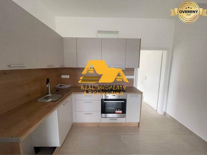 A kitchen in a 3-room apartment with a wooden decor countertop and white cabinets.