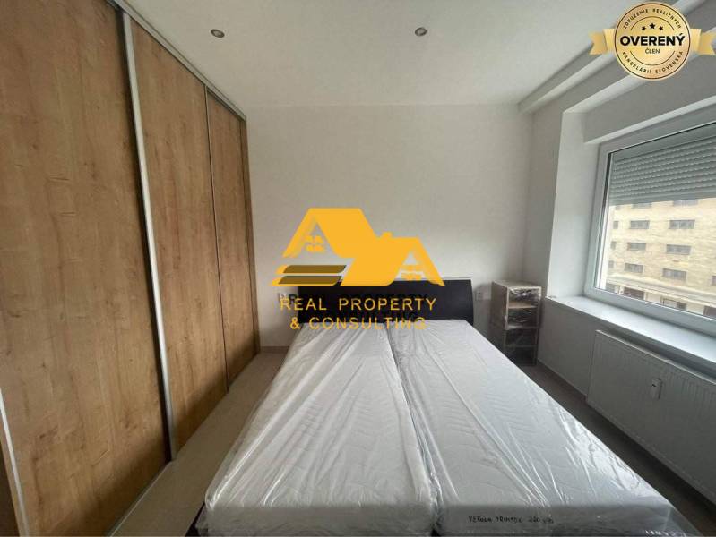 Bedroom in a 3-room apartment with a bed, built-in wardrobe, and a window with a view.