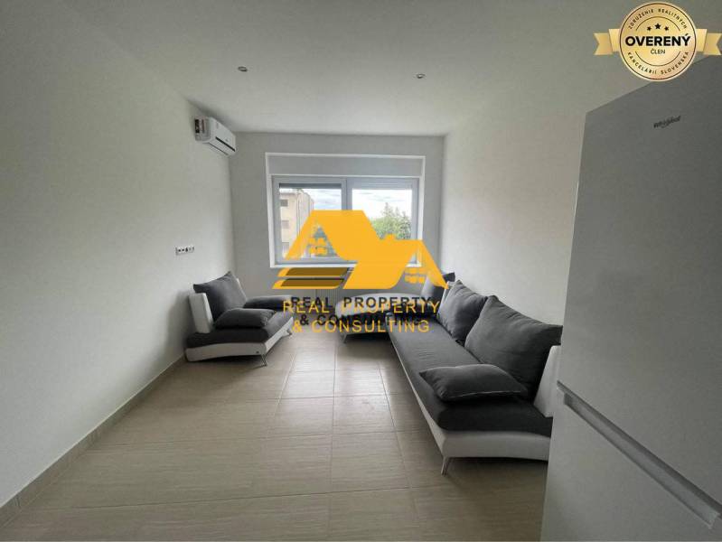 A living room in a 3-room apartment with two gray sofas and a white refrigerator.