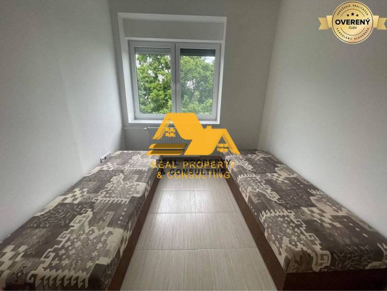 Cozy room in a 3-room apartment with two beds and a view of greenery.