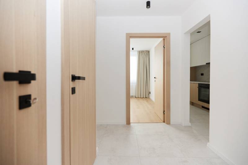 A bright hallway with a wood-effect floor in a 3-room apartment.