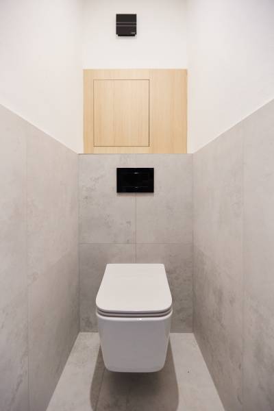 A bathroom with a simple design in a 3-room apartment, white and wooden elements.
