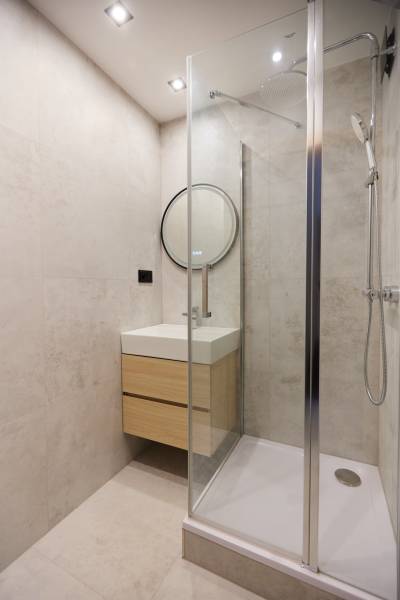 Bathroom in a 3-room apartment with a glass shower enclosure and a modern sink.