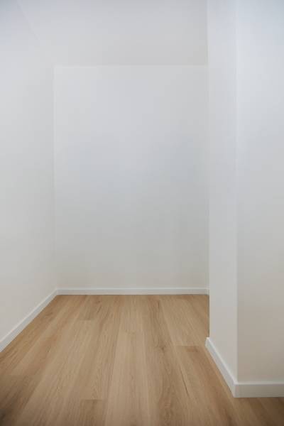 White wall and floor with wood decor in a 3-room apartment.