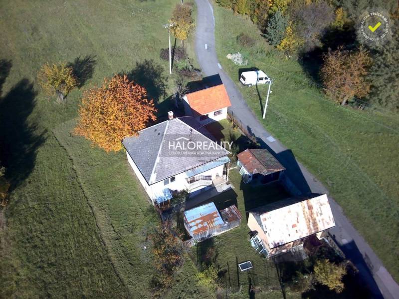 A family house in Malá Lehota surrounded by greenery and an access road.