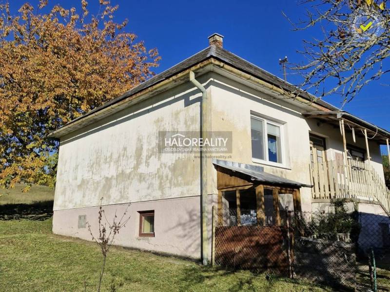 A family house in Malá Lehota with a white facade and fencing in an autumn setting.