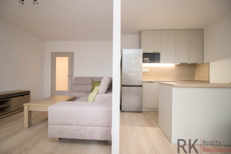Living room with kitchen and wooden decor flooring in a 3-room apartment.