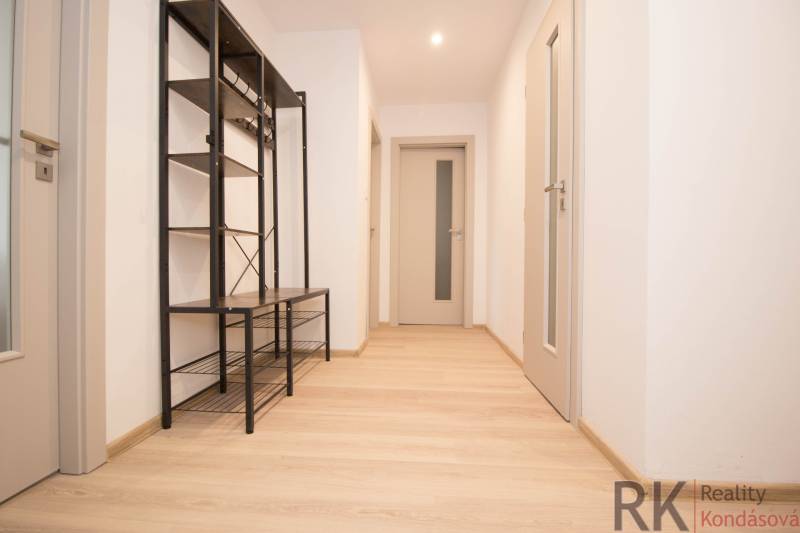 Apartment hallway with shelves and wooden decor flooring, 3-room apartment.